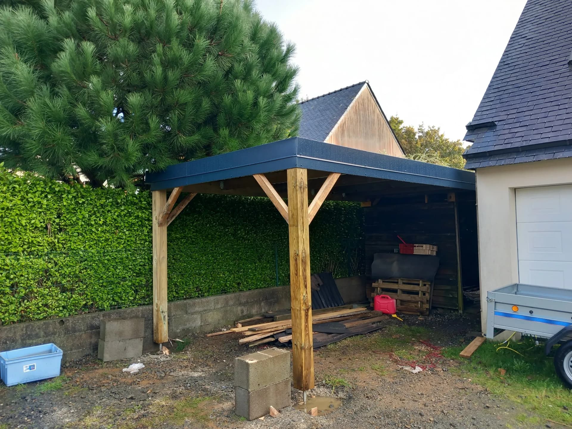 Construction de carport bois avec structure poteaux en place