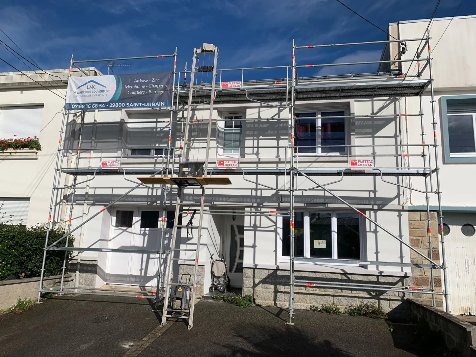Chantier de rénovation de toiture avec échafaudage en façade